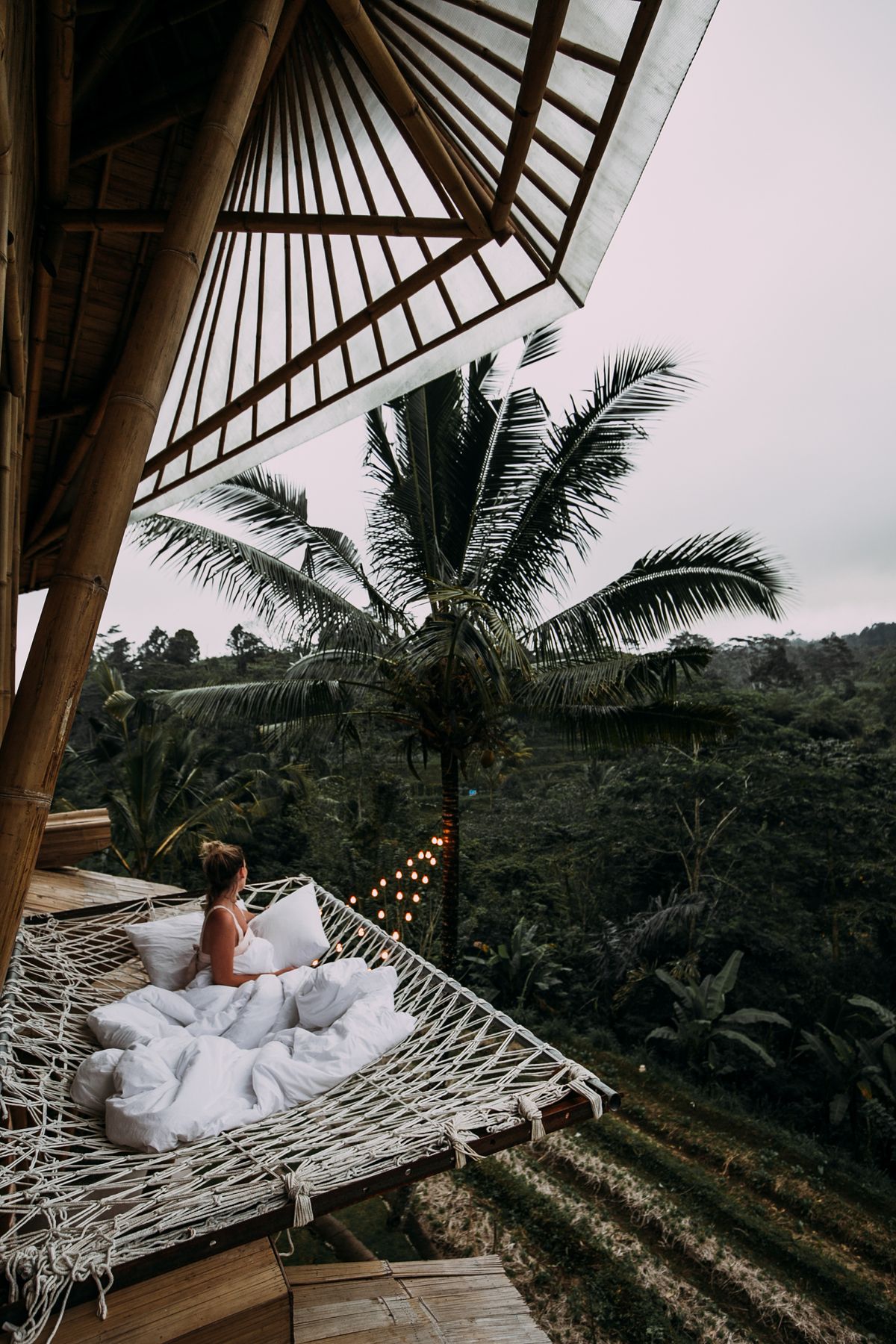 Illustrative stock photo of a woman resting in a hammock among tropical trees